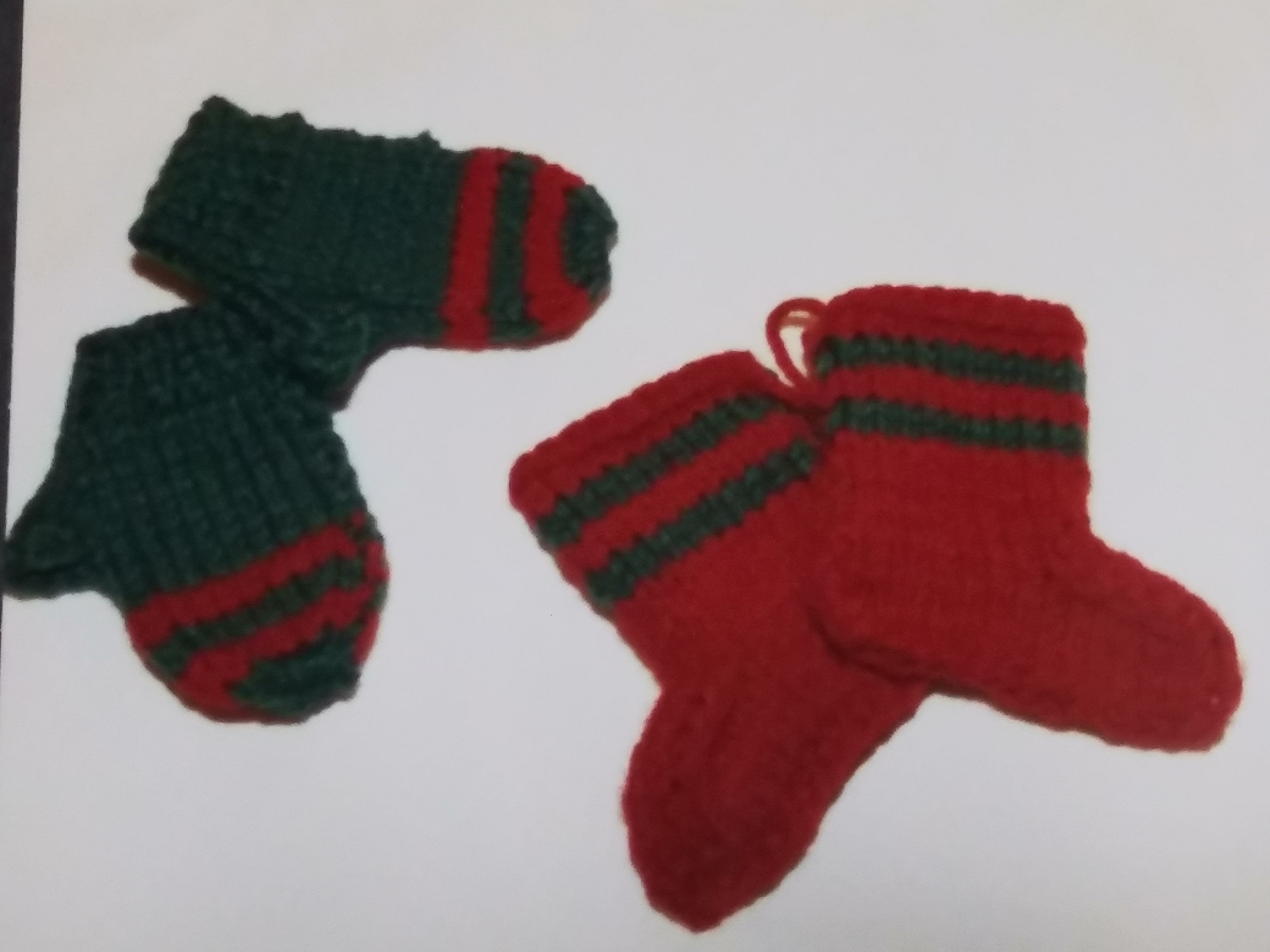 two small green and red mittens and two small red and green stockings